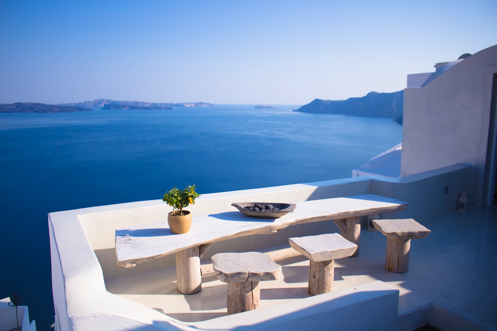 bench and dining table near body of water under calm sky